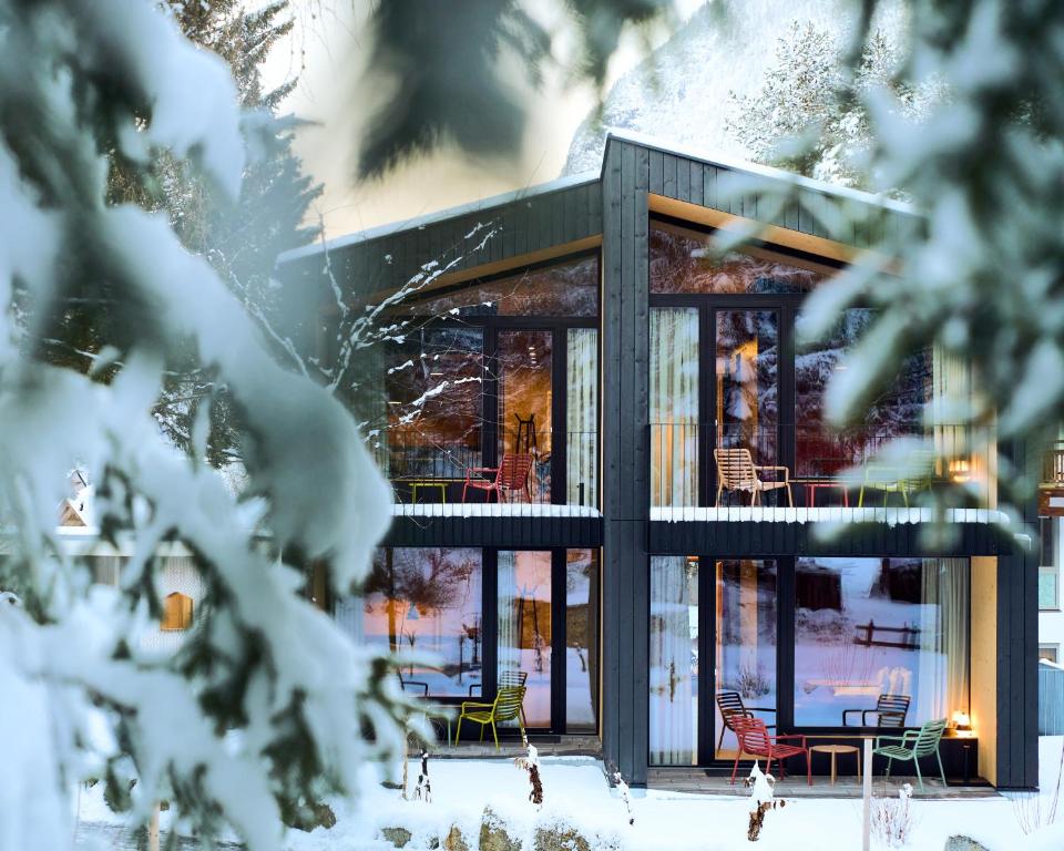 a house in the snow with glass doors at KOKON Apartments in Leutasch