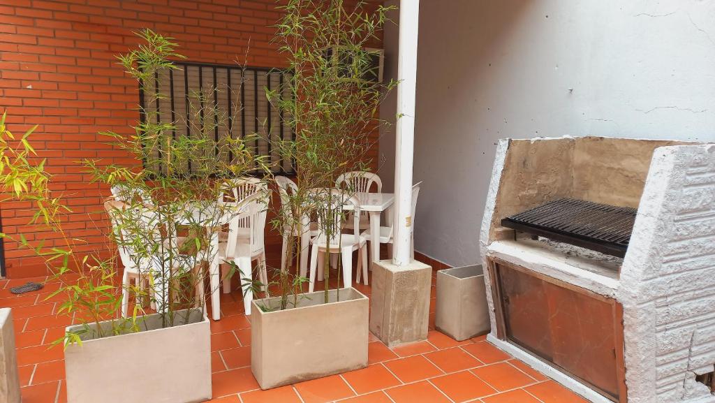 a patio with potted plants and a piano at HABITACIONES en casa palermo con terraza y parrilla in Buenos Aires