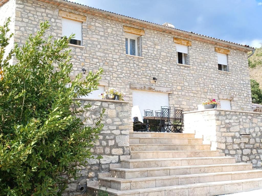 a stone house with stairs in front of it at Chambres d'hôtes Le Prieuré in Noyers-sur-Jabron