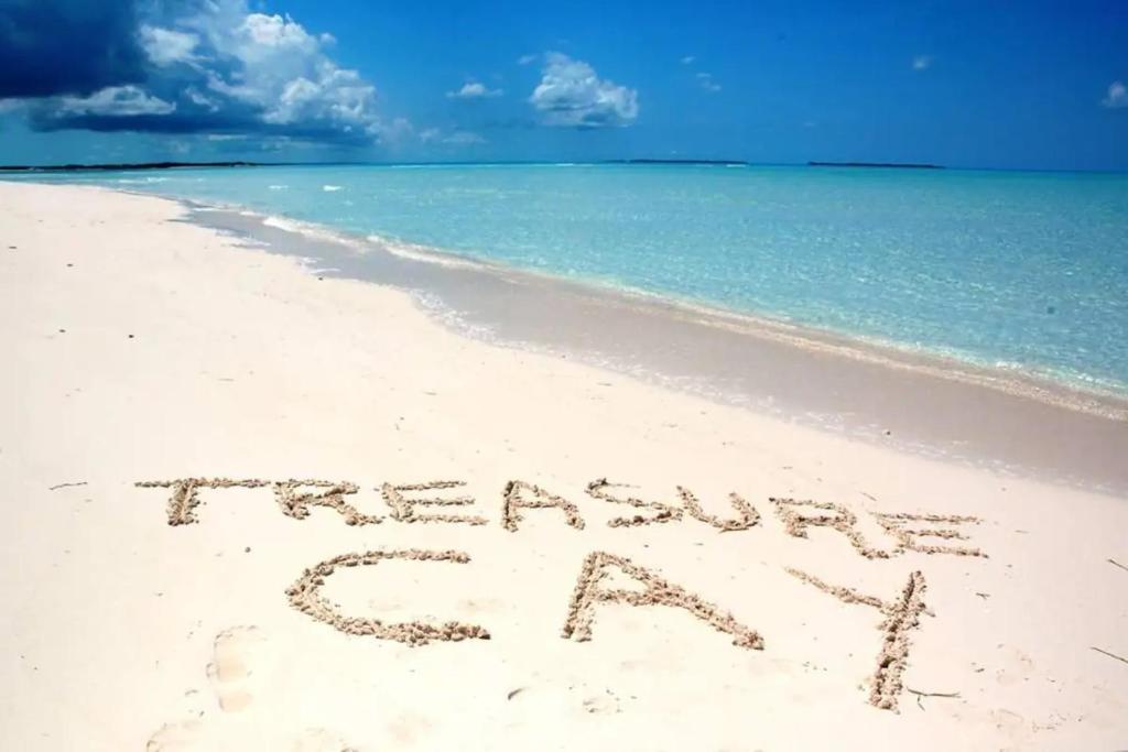 a sign written in the sand on a beach at ,Treasure Cay, Bahamas, Cottages Luis & Sofia, 2 Bed 2 Bath in Treasure Cay