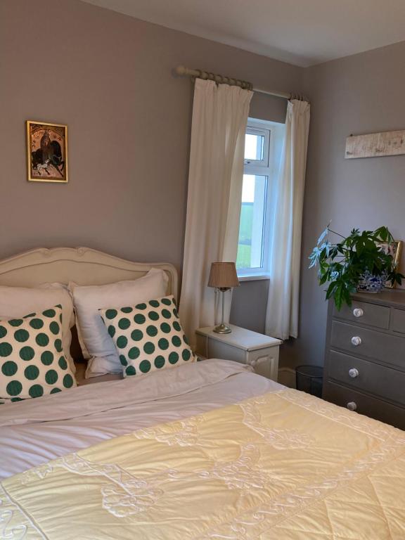 una camera da letto con letto, cuscini e finestra di Hope Valley House a Kingsbridge