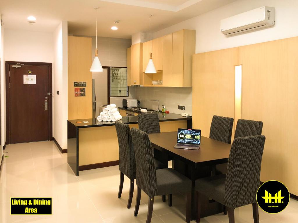 a kitchen and dining room with a table and chairs at VACA Apartments at Imperial Suites in Kuching