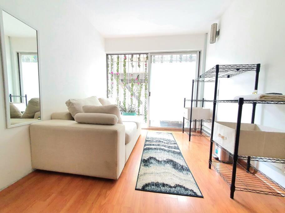 sala de estar con sofá blanco y espejo en Linda Habitacion privada con balcon en Polanco, en Ciudad de México