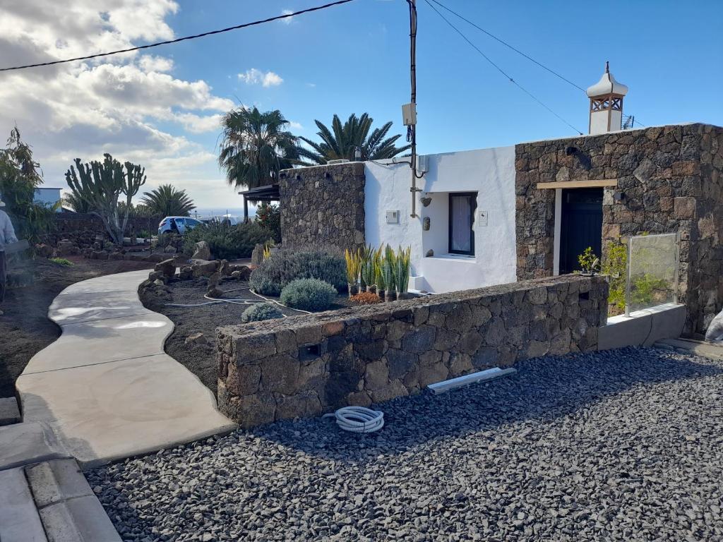 uma parede de pedra ao lado de um edifício em Apartamento con terraza y jardín em Las Breñas