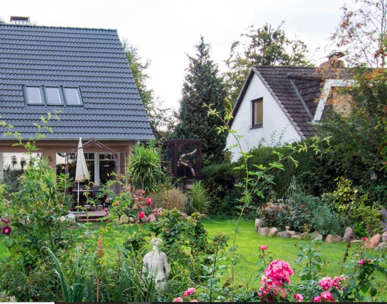 ein Garten vor einem Haus mit Blumen in der Unterkunft Dachgeschosswohnung Scharbeutz mit Garten in Scharbeutz