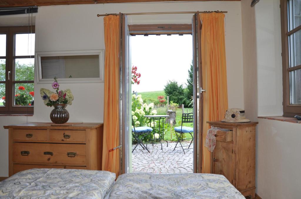 a bedroom with a bed and a sliding glass door at Kemnater Alm in Kaufbeuren