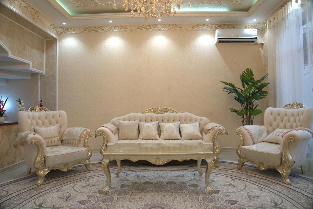 uma sala de estar com um sofá e duas cadeiras em Казахстан 13 em Tashkent