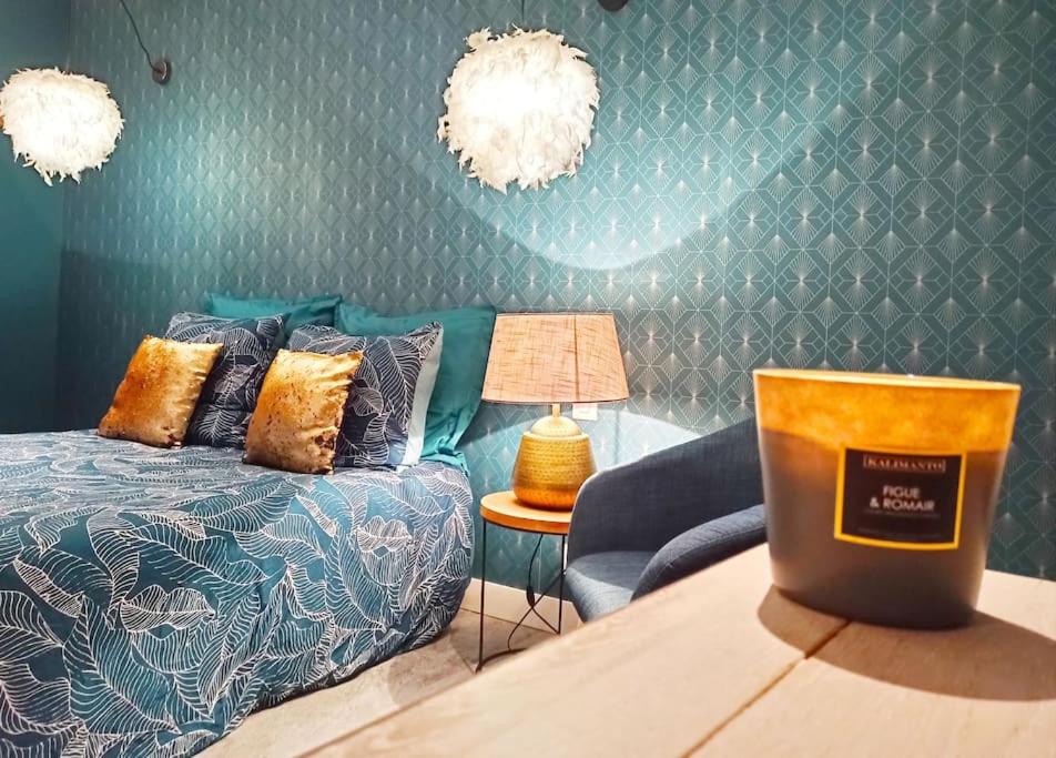 um quarto com uma cama e uma mesa com um candeeiro em Studio confort la plume em Pont-sur-Seine