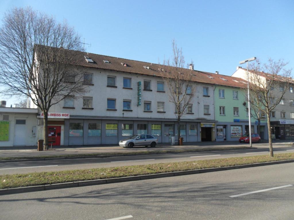 een witte auto geparkeerd voor een gebouw bij hotel funk in Bietigheim-Bissingen