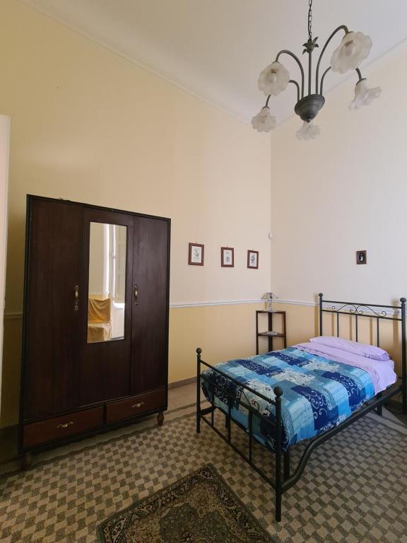 - une chambre avec un lit, une commode et un miroir dans l'établissement Residenza Maria Letizia, à Milo