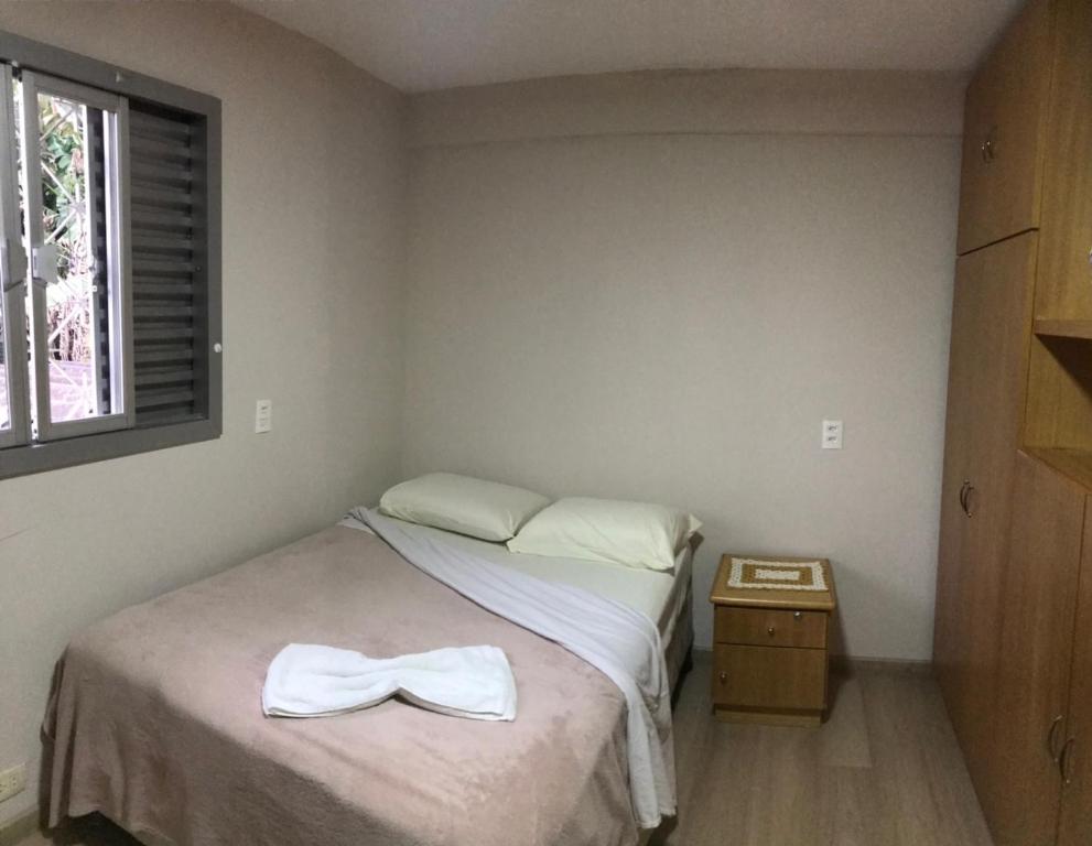 Un dormitorio con una cama con una pajarita. en Residencial Jardim Curitiba, en Curitiba