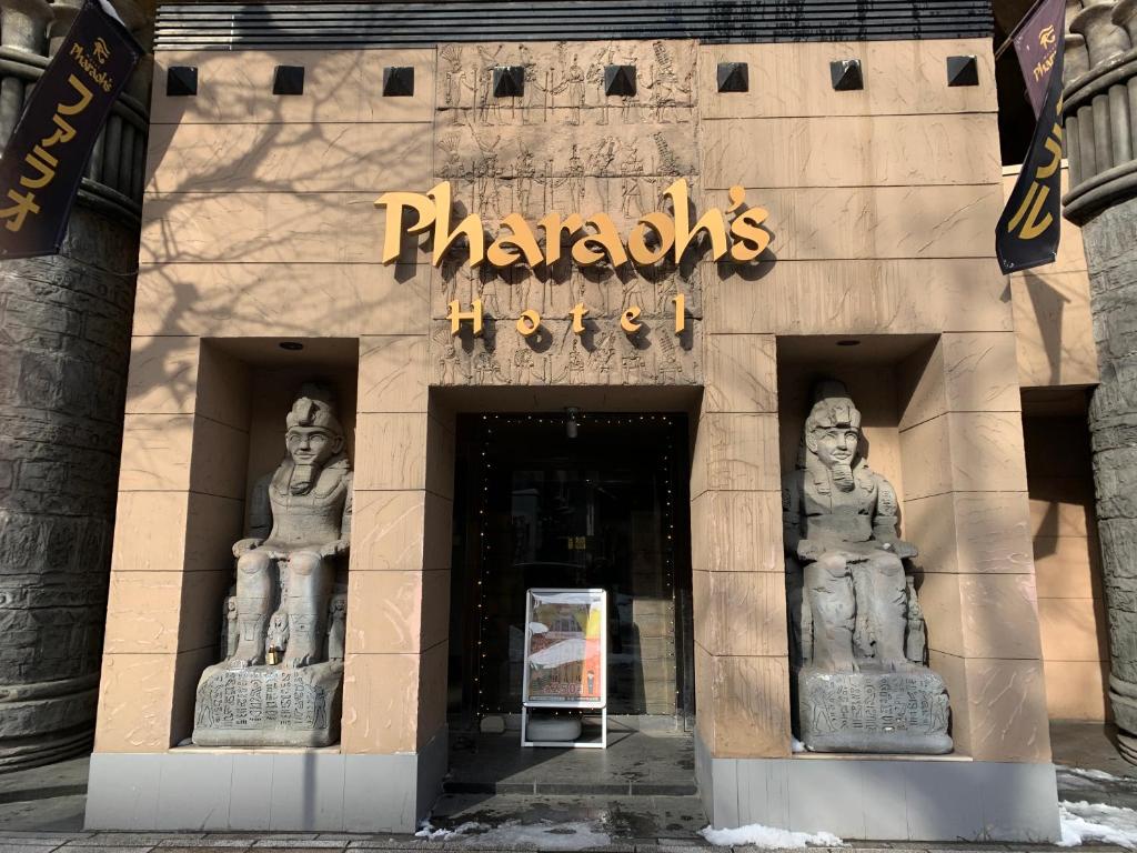 um edifício com duas estátuas na frente dele em Hotel Pharaoh-Adult Only em Sapporo