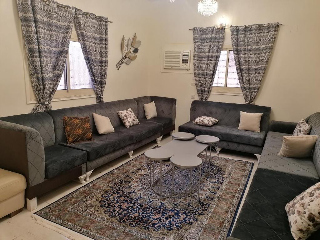 Khair Jewaar Apartments Al Madinah في المدينة المنورة: غرفة معيشة مع أريكة وطاولة