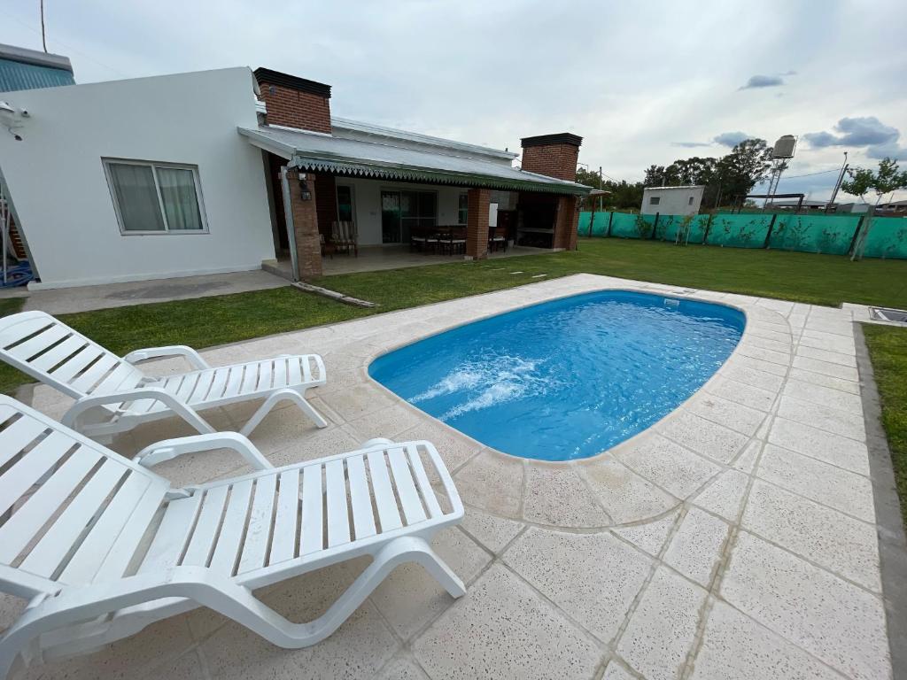 a patio with two chairs and a swimming pool at Casa quinta La Justina in Concepción del Uruguay