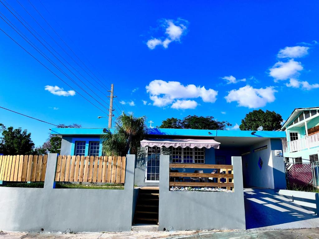 ein blau-weißes Haus mit einem Zaun in der Unterkunft Pirata Family House• A 5 min de Poblado Boquerón in Cabo Rojo