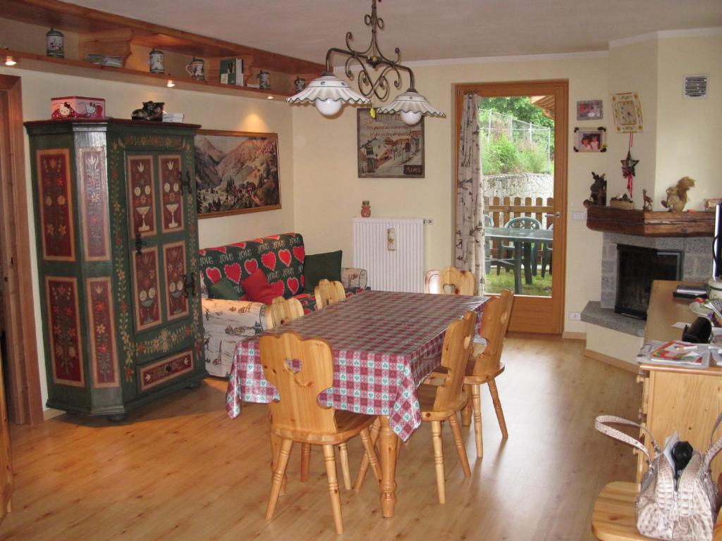 una cucina e una sala da pranzo con tavolo e sedie di le balze di Carisolo, trilocale con giardino a Carisolo
