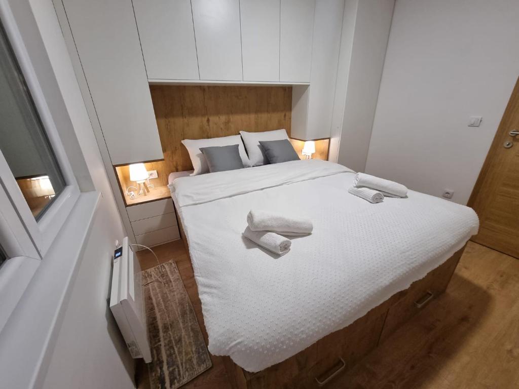 sypialnia z dużym białym łóżkiem z ręcznikami w obiekcie Vila Jahor - Apartmani Trifković w mieście Jahorina