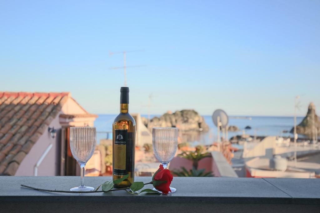 a bottle of wine and two wine glasses on a table at Casa Valastro in Aci Castello