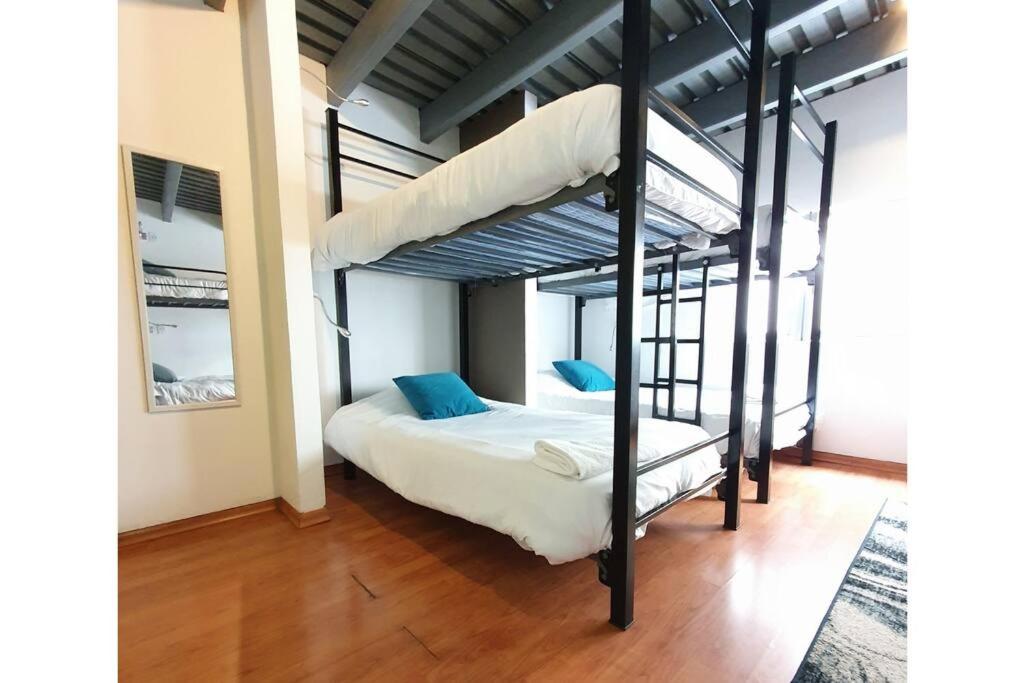 1 dormitorio con 2 literas y almohadas azules en Habitación para 8 personas en Polanco Literas, en Ciudad de México