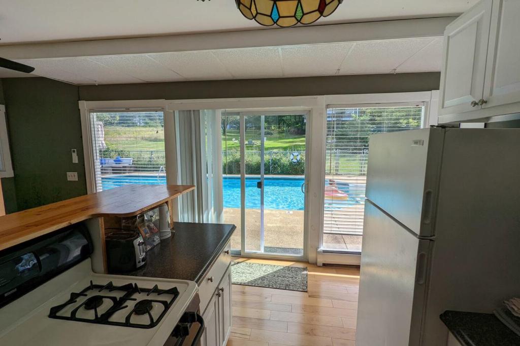 a kitchen with a white refrigerator and a pool at Pool Cottage in Gilford