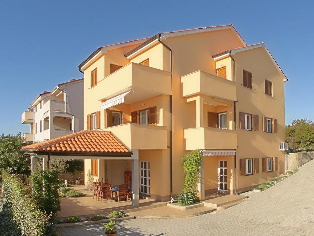 ein großes Apartmenthaus mit einer Terrasse in der Unterkunft Apartment Omanović in Čižići