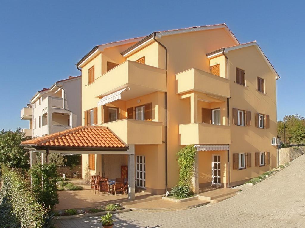 a large apartment building with a patio at Apartment Omanović in Čižići