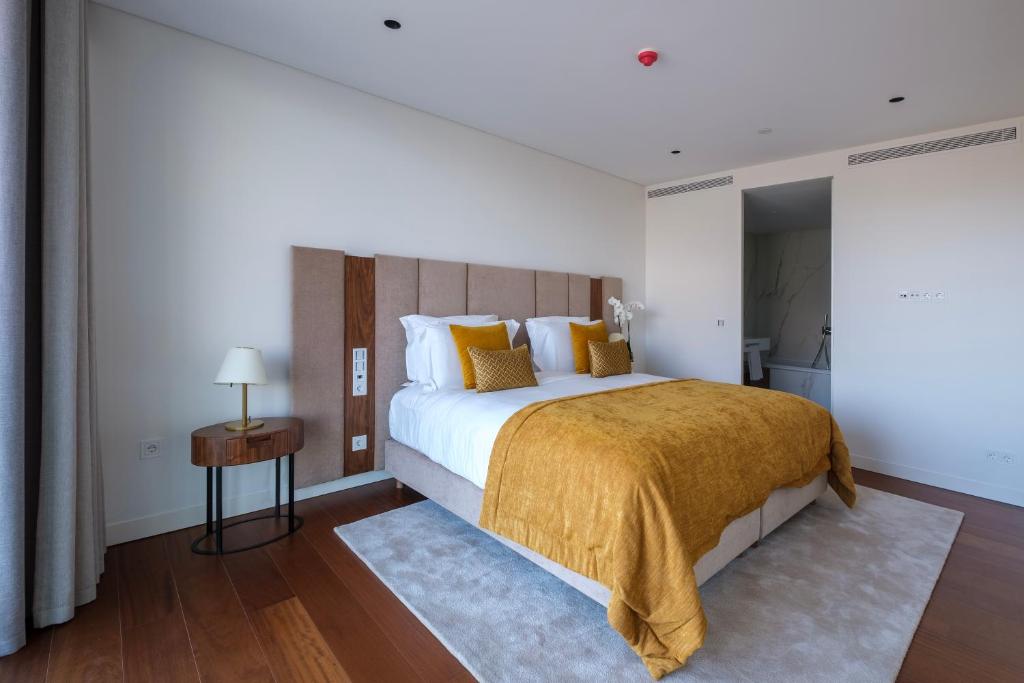 a bedroom with a large bed with a yellow blanket at Martinhal Lisbon Oriente in Lisbon