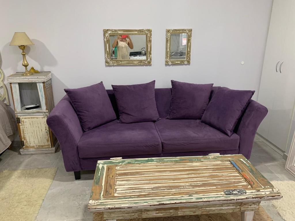 un sofá púrpura en una sala de estar con mesa en Depto Yrigoyen en San Pedro