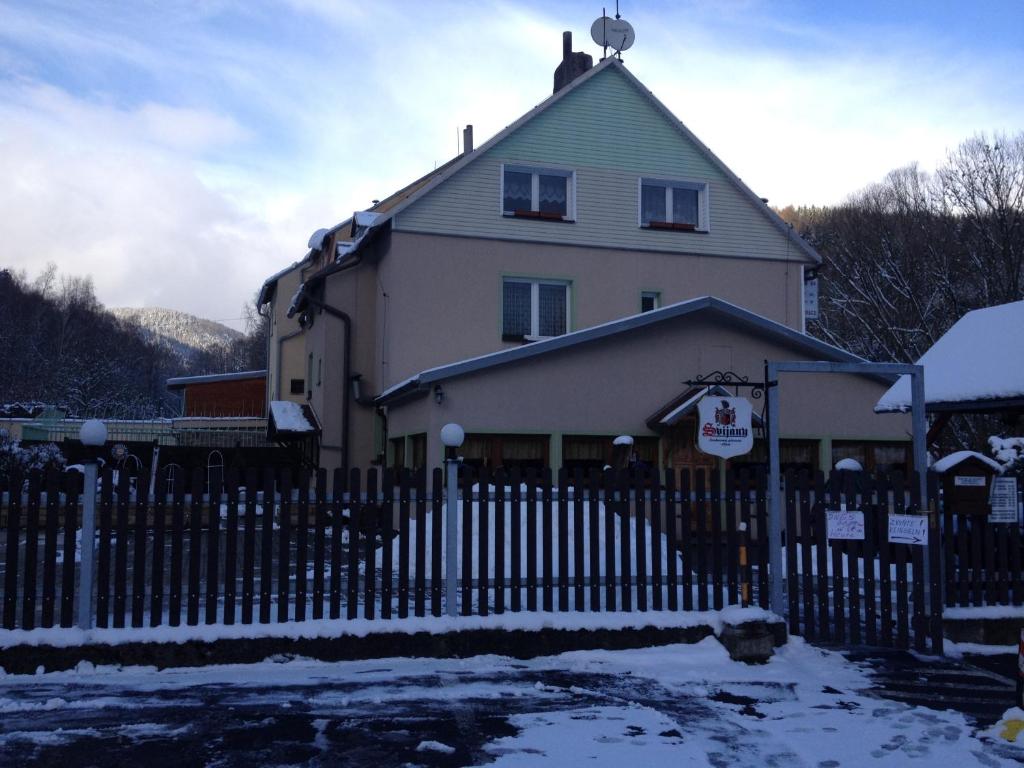 uma casa com uma cerca em frente em Penzion54 & Restaurace em Ostrov