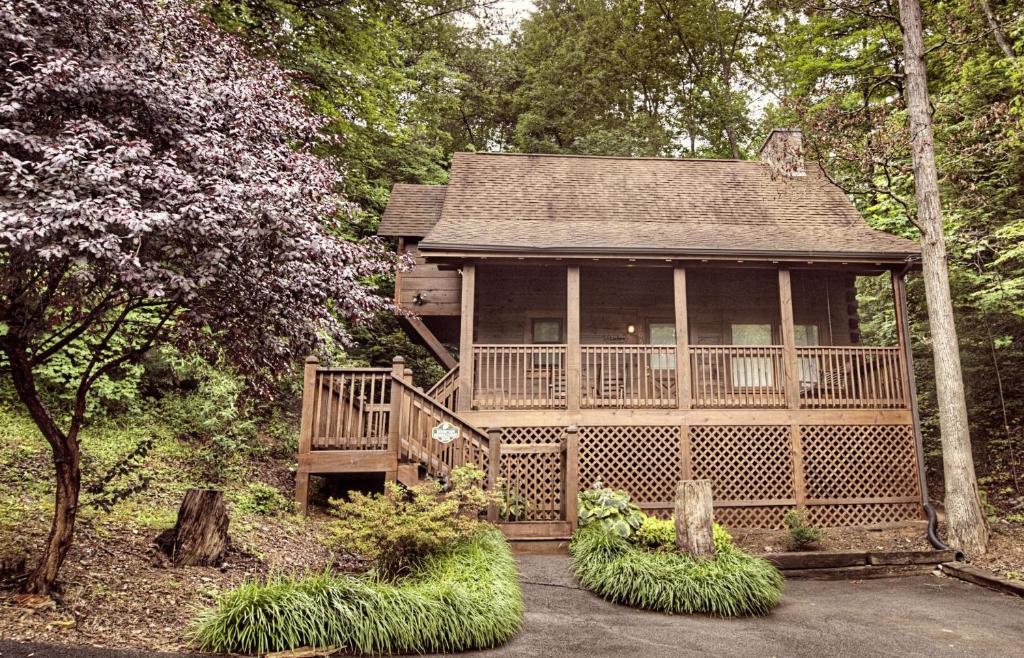 a large wooden house with a deck in the woods at ER206 - Mountain Rendezvous Great location - Close to town! cabin in Pigeon Forge