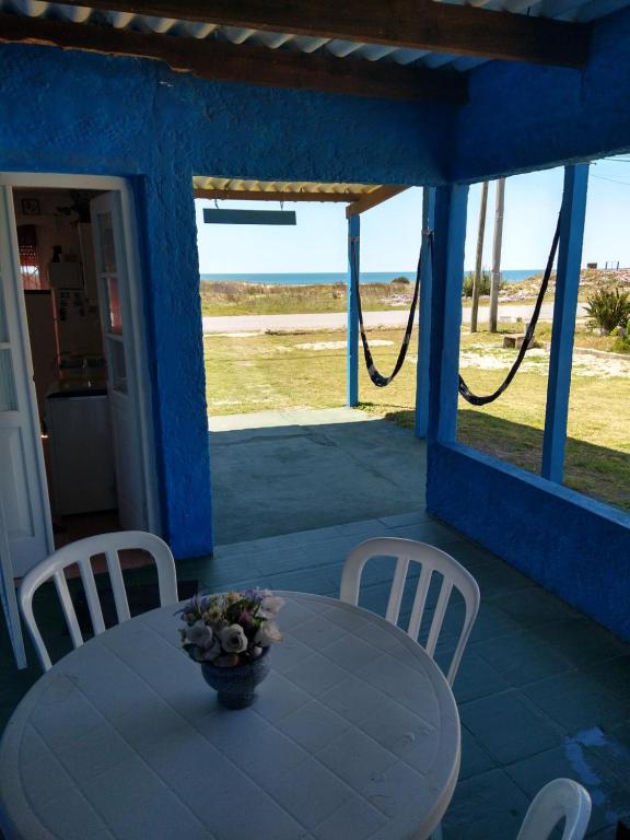 una mesa y sillas en un porche con vistas al océano en Mar en La Paloma