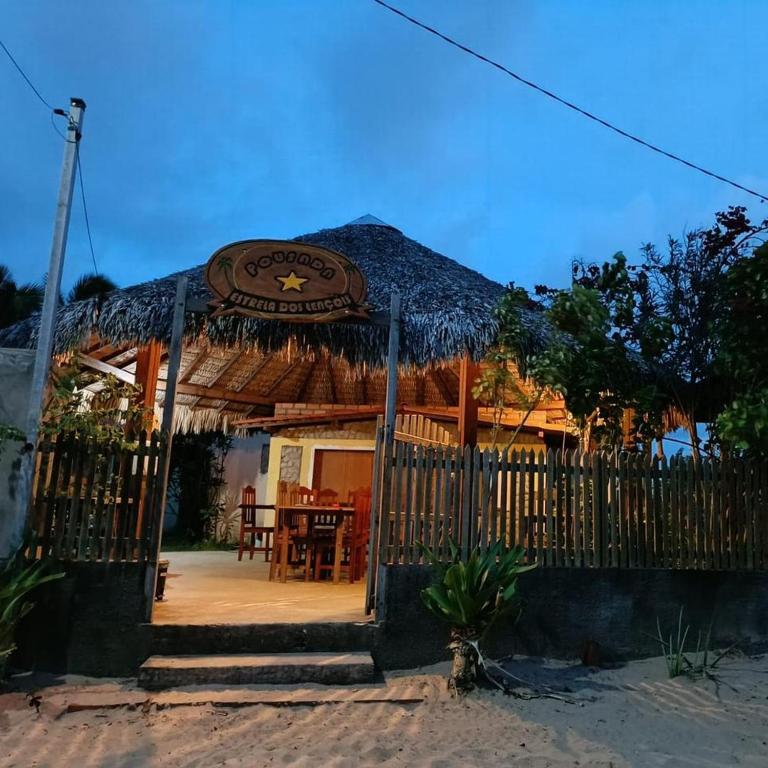 un kiosque avec un restaurant doté d'une table dans l'établissement Estrela dos Lençóis, à Atins