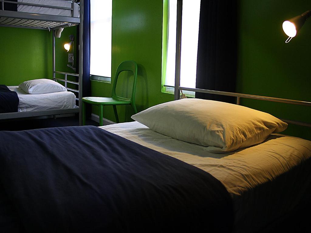 a bedroom with two beds and a green wall at Apple Hostels of Philadelphia in Philadelphia