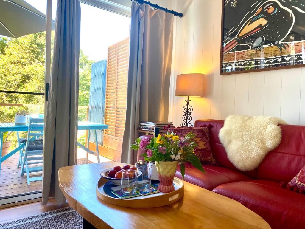 a living room with a red couch and a coffee table at Willow Cabin in Beechmont