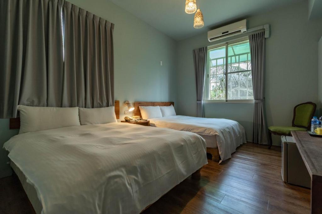 a bedroom with two beds and a window at Cloud Sun Homestay in Zhixue