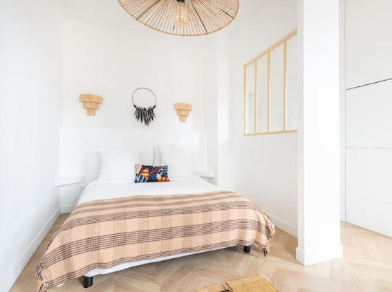 une chambre avec un lit avec une couverture dessus dans l'établissement Nau, à Marseille