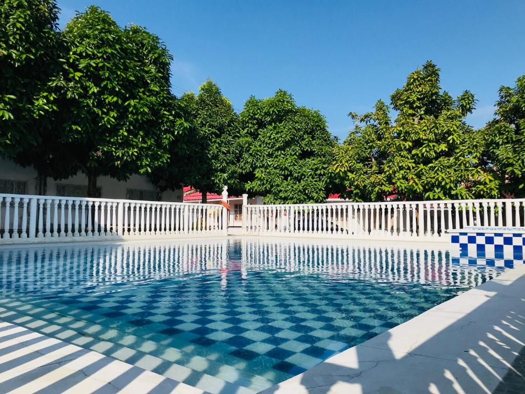 a swimming pool with a white fence and trees at EL DESCANSO DEL HACARITAMA in Melgar