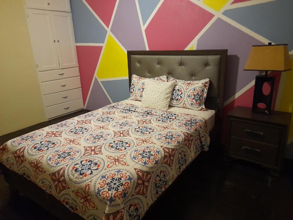 - une chambre avec un lit et un mur coloré dans l'établissement Tropical Suites, à Choiseul