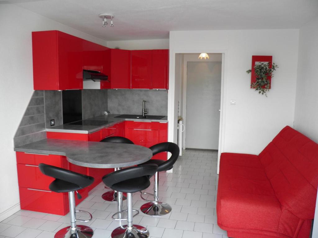 セットにあるAppartement Sète, 2 pièces, 4 personnes - FR-1-338-161の赤いキャビネット、テーブル、赤いソファ付きのキッチン
