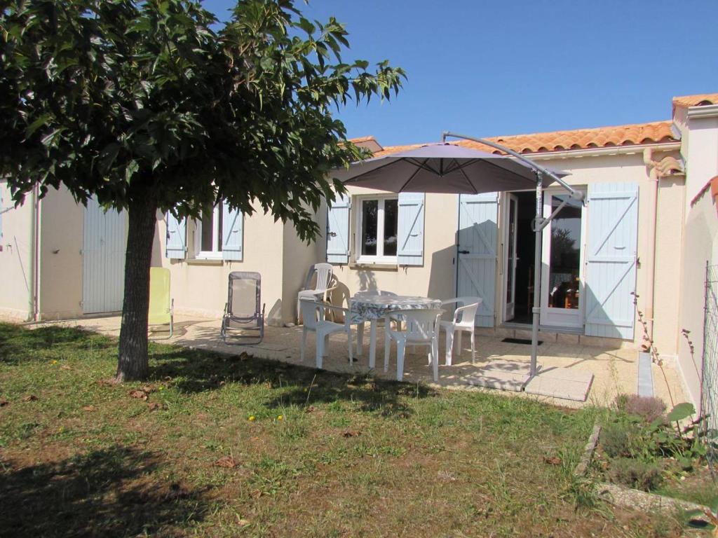 een patio met een tafel en een parasol bij Maison La Brée-les-Bains, 3 pièces, 5 personnes - FR-1-246A-181 in La Brée-les-Bains