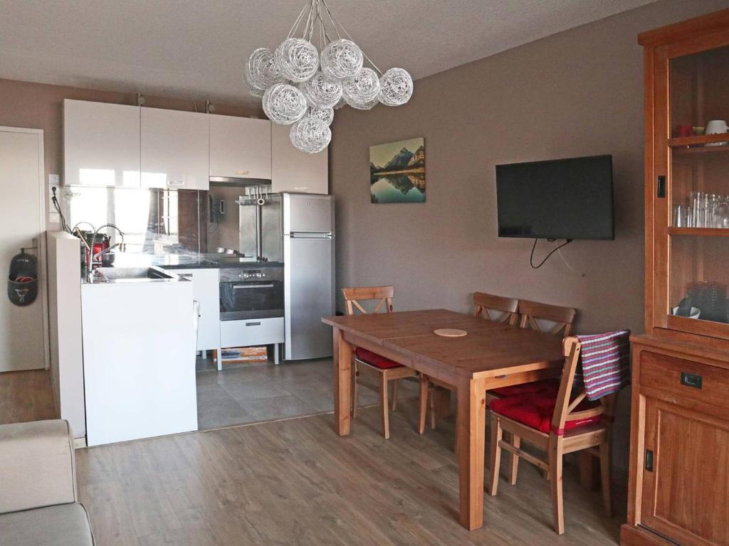 kuchnia i jadalnia ze stołem i lodówką w obiekcie Appart 2 pièces 6-8 pers, accès direct pistes - FR-1-322-514 w mieście Les Orres
