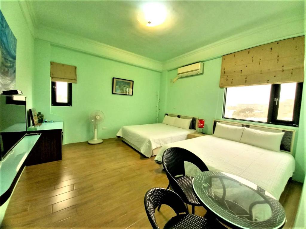 a room with two beds and a table and chairs at Dreamily Fish B&B in Magong