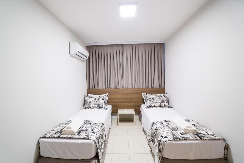 een slaapkamer met 2 bedden en een raam bij Serra Madre Residence in Rio Quente