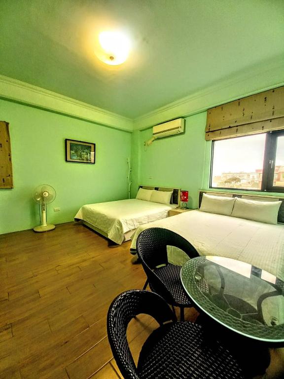 a room with two beds and a table and chairs at Dreamily Fish B&B in Magong