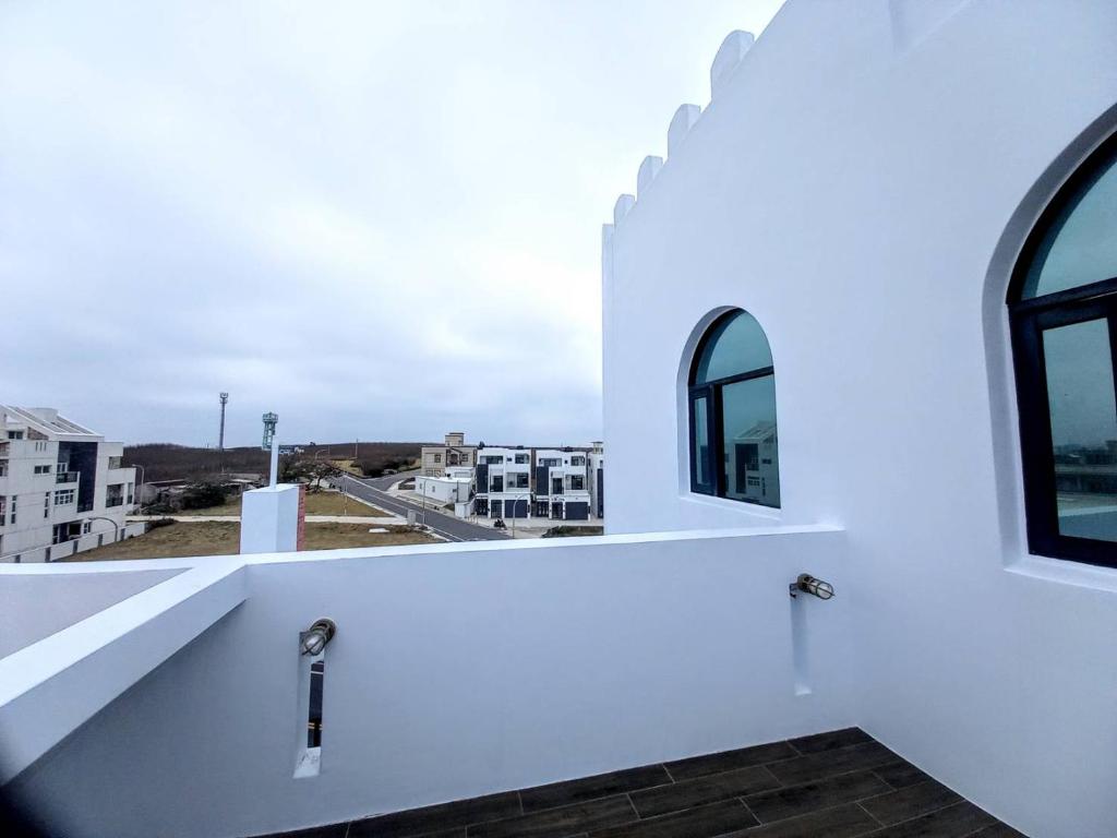 a white building with windows and a view of a city at Dreamily Fish B&B in Magong