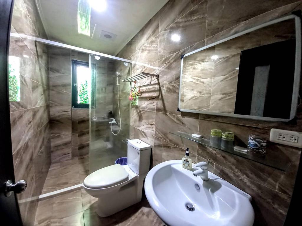 a bathroom with a sink and a toilet and a mirror at Dreamily Fish B&B in Magong