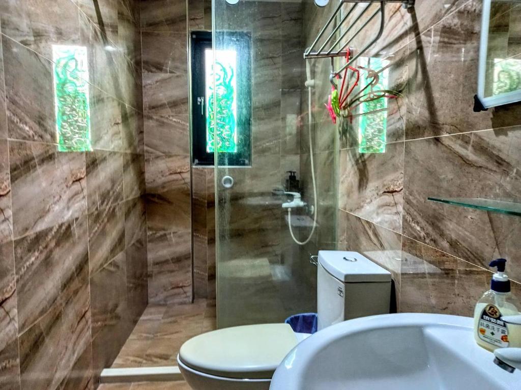 a bathroom with a toilet and a shower and a sink at Dreamily Fish B&amp;B in Magong