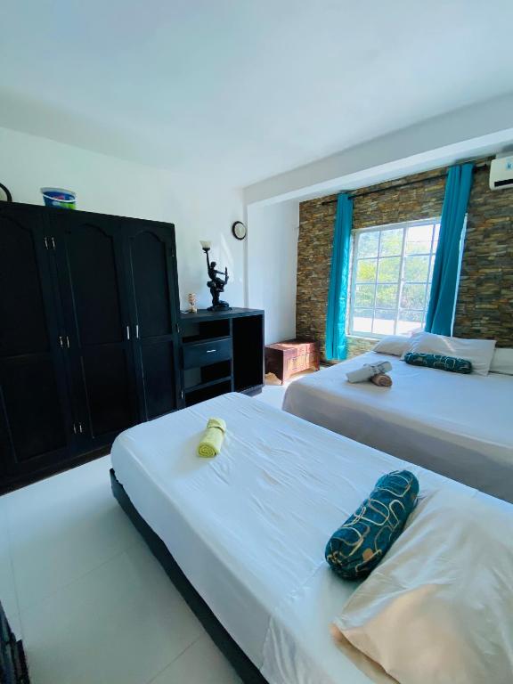 Un dormitorio con dos camas y una ventana. en Apartamentos Sweet Island, en San Andrés