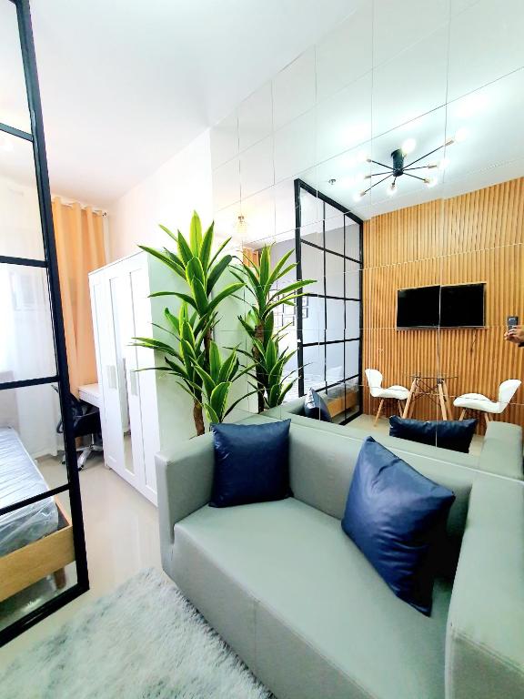 a living room with a couch with blue pillows at Green 2 Residences Scandi-Industrial Hotel Type Interior in Dasmariñas