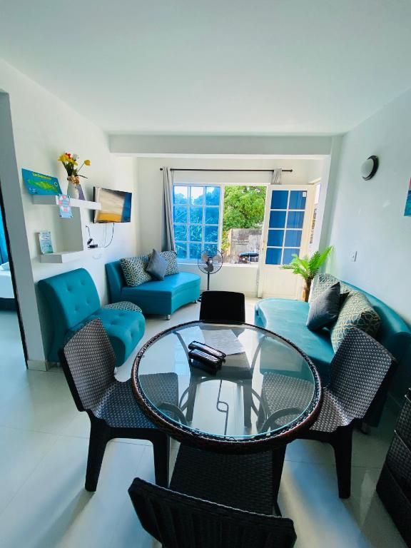 sala de estar con mesa de cristal y sillas en Apartamentos Sweet Island, en San Andrés